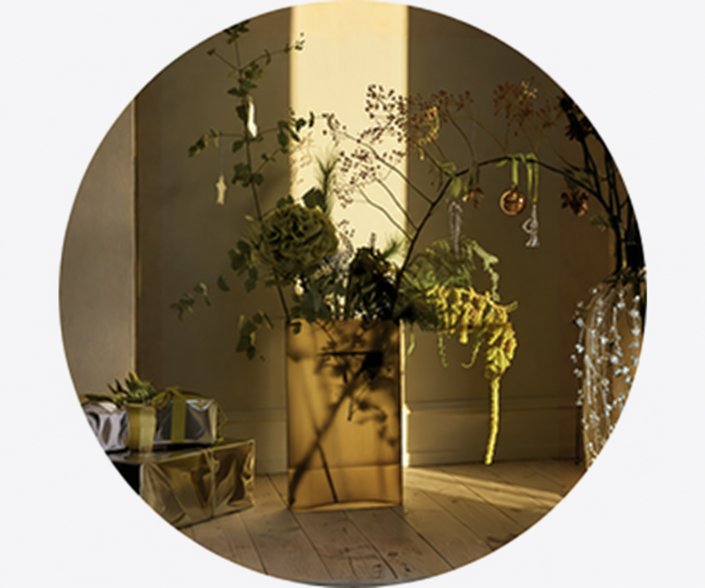 Festive floral arrangement with wrapped gifts and elegant holiday decorations in warm golden light